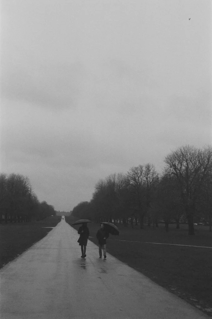 Black and white picture of a couple walking under the rain